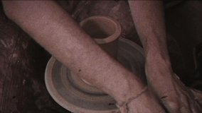 Vintage effect. The potter makes a jug of clay. Family video archive. Retro.  Ceramist. A man makes a vase on a potter's wheel. Handwork. Pottery.  Clay dishes