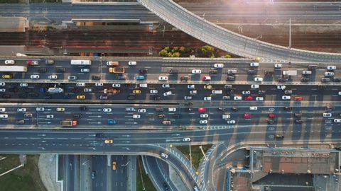Beautiful aerial view to the cars driving on multi-level highway in Moscow. Direct view from above to the road traffic in a big city on the sunny evening.