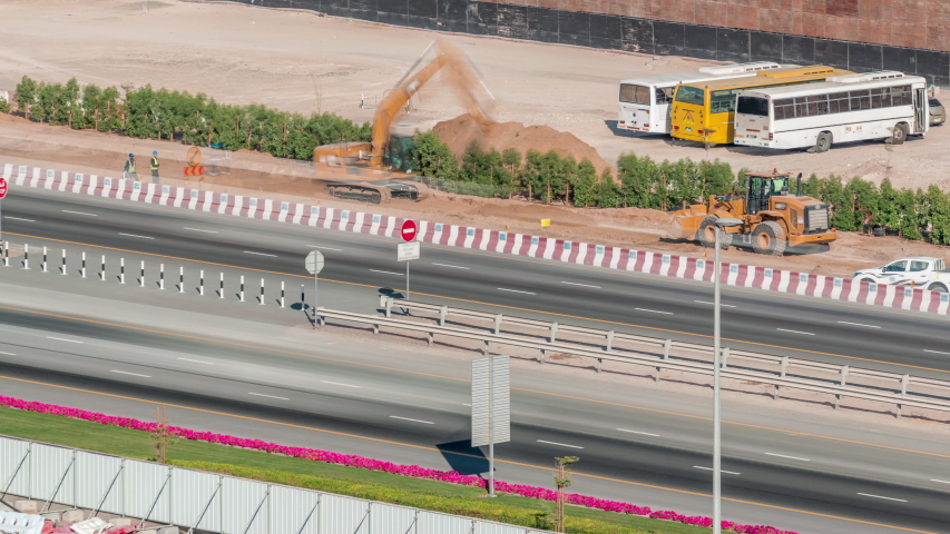 Constucting with special machines and engeneers near road with fast traffic in Business Bay, Dubai, United Arab Emirates aerial timelapse