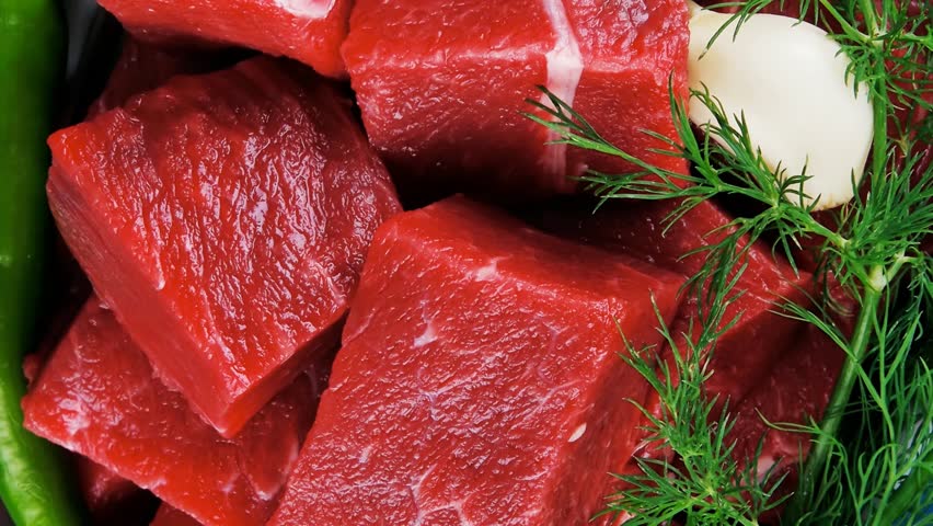 slices of raw fresh beef meat fillet in a white bowls with dill and green peppers serving over blue wooden table 1920x1080 intro motion slow hidef hd