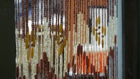 Wooden curtains swing in draft in the doorway. A bamboo curtain sways in the wind. Handmade curtains of wooden beads near. Relaxing background with moving vertical sticks. Interior ecology elements - Powered by Shutterstock - Get 15% off with code: PIKWIZARD15