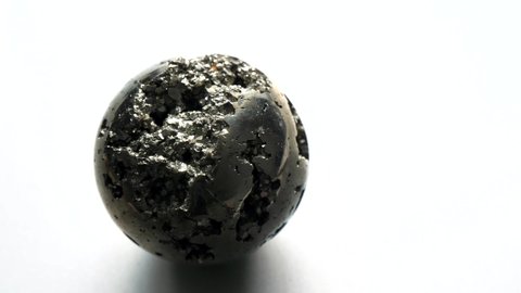 Beautiful iron ball of natural pyrite rotation, revolves around itself and its axis On a white background. Golden and golden ball or pyrite sphere. ?ollection Natural stones, crystals. Minimalism