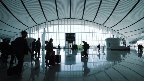 Beijing, China – September 30, 2019: Slow Motion - Silhouettes of people walking at Beijing Daxing New International Airport Terminal (PKX) in China.