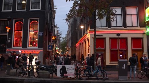 AMSTERDAM, NETHERLANDS - OCTOBER 26, 2019: Nightlife on the Street of Red Lights and Sex industry of Amsterdam, Pedestrians, Clubs, Shops