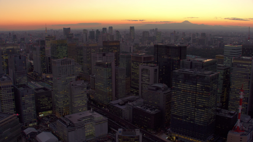 Tokyo, Japan circa-2018. Flying over Tokyo skyscrapers at dusk. Shot from helicopter with RED camera.