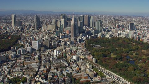 Tokyo, Japan circa-2018. Aerial view of Shinjuku Gyoen National Garden and Shinjuku buildings. Shot from helicopter with RED camera.