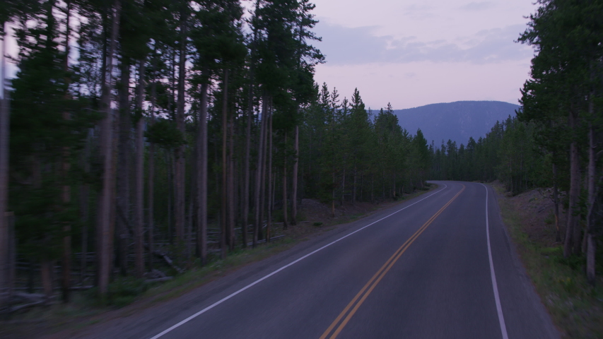 Driving along road at sunset, Yellowstone National Park