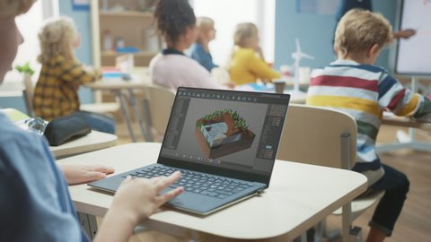 Elementary School Computer Science Classroom: Over the Shoulder View of a Kid Using Laptop to Design 3D Game, Building Level in Strategic Roleplaying Videogame