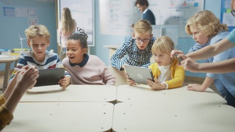Elementary School Computer Science Class: Schoolchildren Use Digital Tablet Computers and Smartphones with Augmented Reality Software, They’re Excited, Full of Wonder, Curiosity. Children in STEM