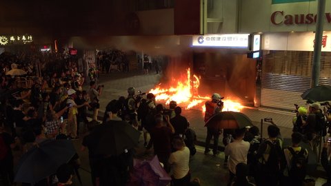 HONG KONG – 4 OCTOBER 2019: Hong Kong protests - camera crews film burning Construction Bank office after it was set on fire by angry radical demonstrators