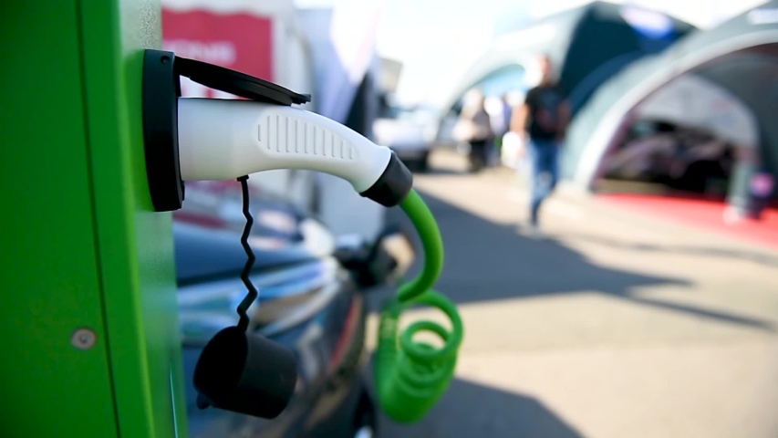 Electrical car plugged through a charging cable to a charging station. | Shutterstock HD Video #1040169926