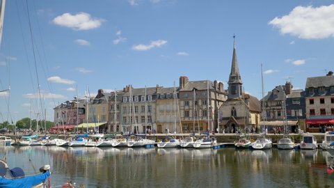 HONFLEUR, FRANCE - JUNE 2018: Honfleur harbour old port with beautiful houses and lots of yachts. Honfleur is located in the northern region of Calvados, Normandy, France.
