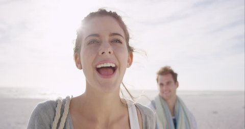 Young couple holding hands woman leading boyfriends walking towards sunset on empty beach Vídeo Stock