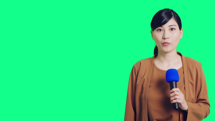 Female asian reporter. Green background of chroma key composition. | Shutterstock HD Video #1040198534