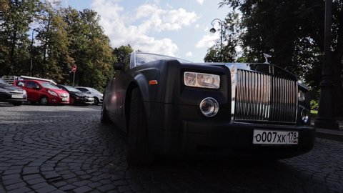 SAINT-PETERSBURG, RUSSIA - SEPTEMBER 20, 2019: Luxury premium car rides on the road. Black Rolls-Royce Phantom limousine sedan in town.