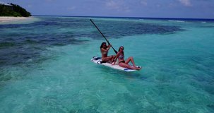 Two girls tourists on the paddleboard sunbathing and relaxing in Thailand