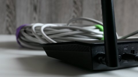 Black Wireless Router On The Desk, Wires, Cables Panning Slider Shot.