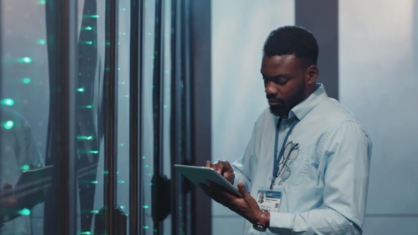 In big data center team of multi-ethnic IT server engineers inspecting working server computers. Man and woman technicians working together in high tech server rack room. | Shutterstock HD Video #1040230082