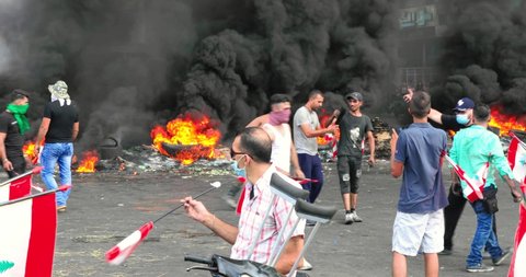 Beirut / Lebanon - 10 18 2019: Rioters on the streets of Beirut, Lebanon, huge fires in the background