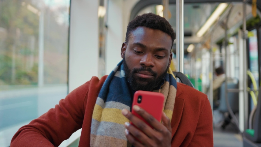 Portrait serious portrait african american man use smartphone look at camera feel sick sitting in tram traffic typing handsome passangers stylish transportation internet online texting guy slow motion | Shutterstock HD Video #1040232566