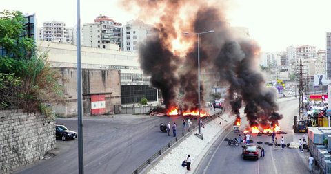 Beirut / Lebanon - 10 18 2019: Protestors block a street with burning tyres in Beirut, Lebanon. The public are revolting against the political elite