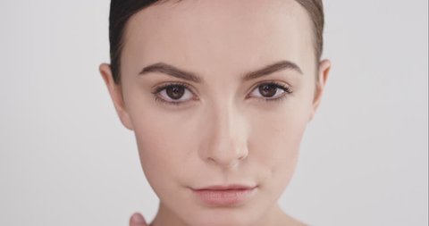 Close up beauty portrait of beautiful woman leaning head on arms in slow motion skincare concept shot against grey background shot in 6K Red Epic Dragon
