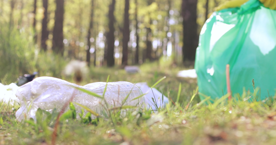 Close up view of plastic on green grass in a public city park, selected by volunteers from nonprofit volunteers.Cleaning the park by volunteers in the spring. Royalty-Free Stock Footage #1040243660