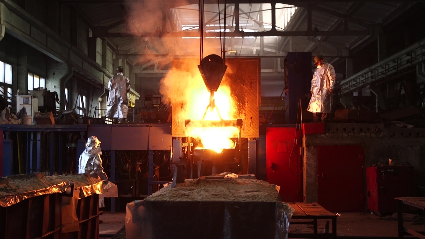 Hard work in the foundry. Pouring molten steel. Liquid steel pouring.