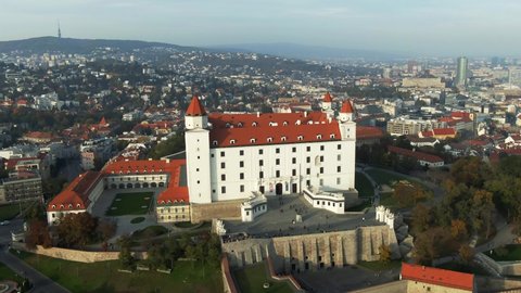 Aerial Panorama Shot of Tourists Enjoying Bratislava Castle With Cityscape And Whole Old Town in the Background During a Foggy Autumn Evening in Bratislava, Slovakia