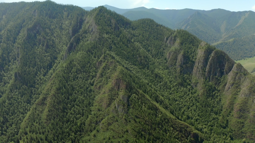 Aerial - Flying low above the turquoise color river carving its way through the spring valley