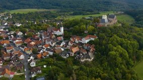 Aerial view of the city Hering, Otzberg im Odenwald in Germany. On a cloudy day in autumn. Zoom out from the castle.