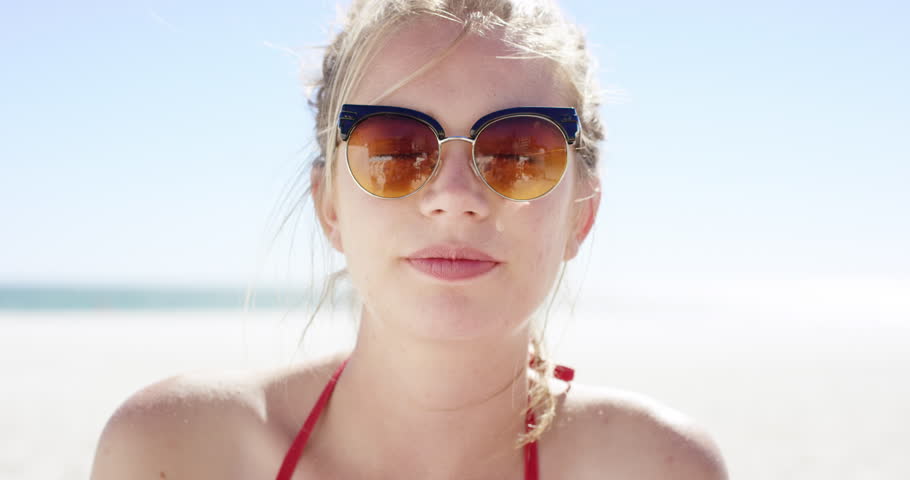 Close up portrait of beautiful young teenage girl smiling on tropical beach slow motion