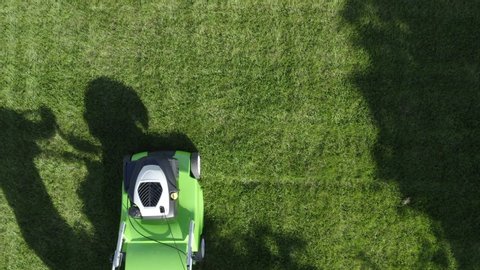 Professional Gardener in His 30s with His Gasoline Lawn Mower. Professional Summer Landscaping Works. Aerial Footage.