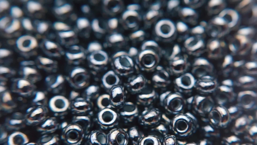 Craftsmanship: Highlighting the intricate and precise craftsmanship involved in creating the beads. Close-up of black single hole glass czech beads. Fashion Accessories close-up details. Closeup beads Royalty-Free Stock Footage #1040289563