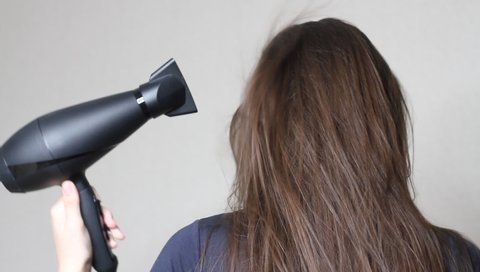 Close up video of  Woman drying hair using black hair dryer