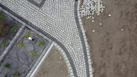 Residential Granite Brick Paving by Caucasian Construction Industry Worker. Aerial Footage.
