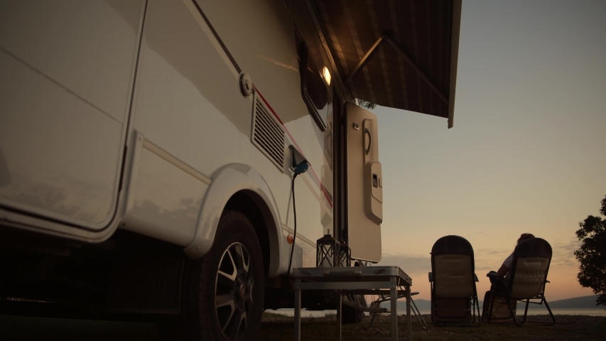 Motorhome Camping Vacation. Woman Relaxing in Front of Her Camper Van Motorhome.