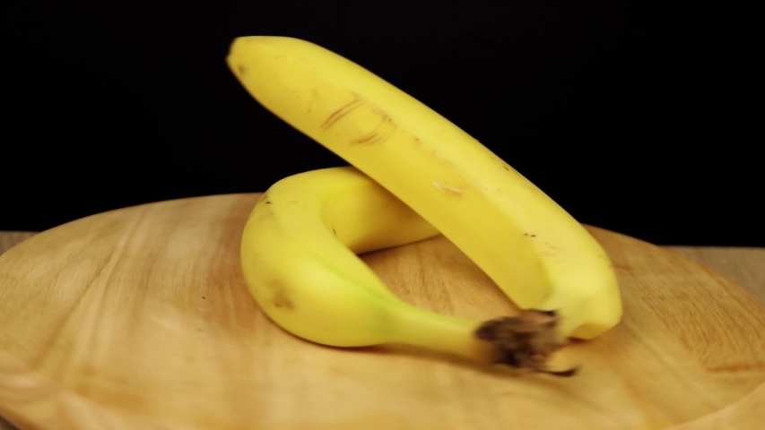 2 bananas rotate 360 degrees on wooden stand