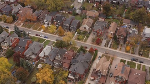 Aerial shot of suburban Toronto neighbourhood during peak fall colors. Cinematic 4K footage.