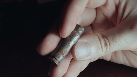 Holding a corroded bullet casing, war artifact