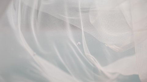 A white translucent veil blowing in the wind.