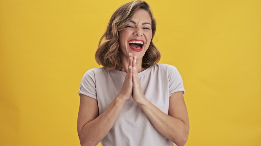 Charming and happy young woman with red lips laughing and dancing over yellow background isolated | Shutterstock HD Video #1040322164