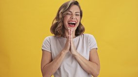 Charming and happy young woman with red lips laughing and dancing over yellow background isolated
