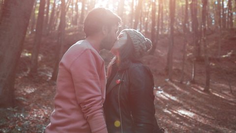 Happy couple is kissing in autumn time on forest. Lovers concept, happy handsome man and beautiful girl is romantic date in park. Leaves and love time. Married people.  Video de stock