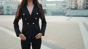 Young adult businesswoman standing in city in suit