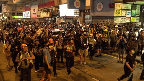HONG KONG – 7 OCTOBER 2019: Camera crews and photographers surround a taxi driver that drove through a crowd of protesters near Prince Edward MTR station, during demonstrations in Hong Kong