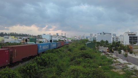 Nha Trang, Khánh Hòa / Vietnam 10.14.2019  a flying camera rises above a freight train and overlooks the city of Vietnam Nha Trang