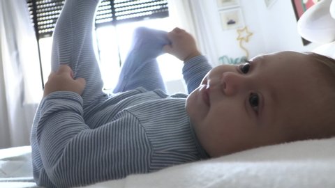 
Sweet cute toddler infant layed in bed looking to camera happy
