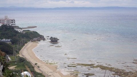 Sea cliff coast with white sand beach view of okinawa sea at Cape Hedo in okinawa island with some tree in summer daytime with wind blowing