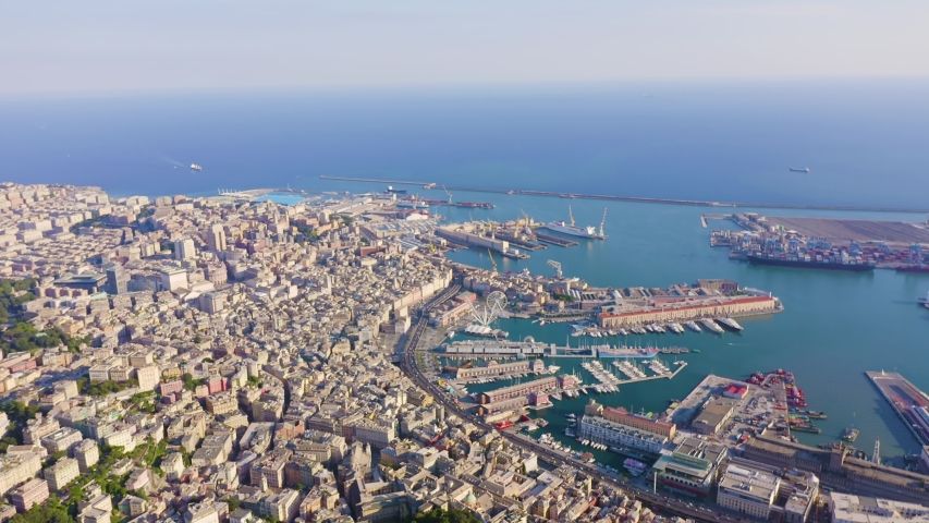 Genoa, Italy. Aerial panorama over the historic port, colorful buildings, and bustling harbor with ships on the shimmering Mediterranean under clear summer sky. Aerial view